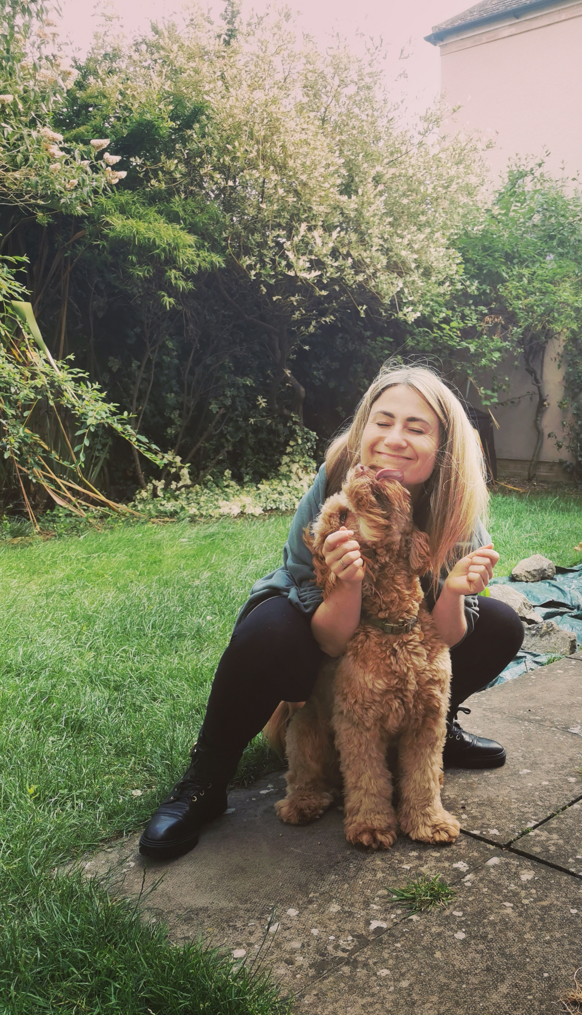Kamila, the Ruff Pooch's primary dog trainer, and her dog Alf, excited to see her and trying to give her kisses.